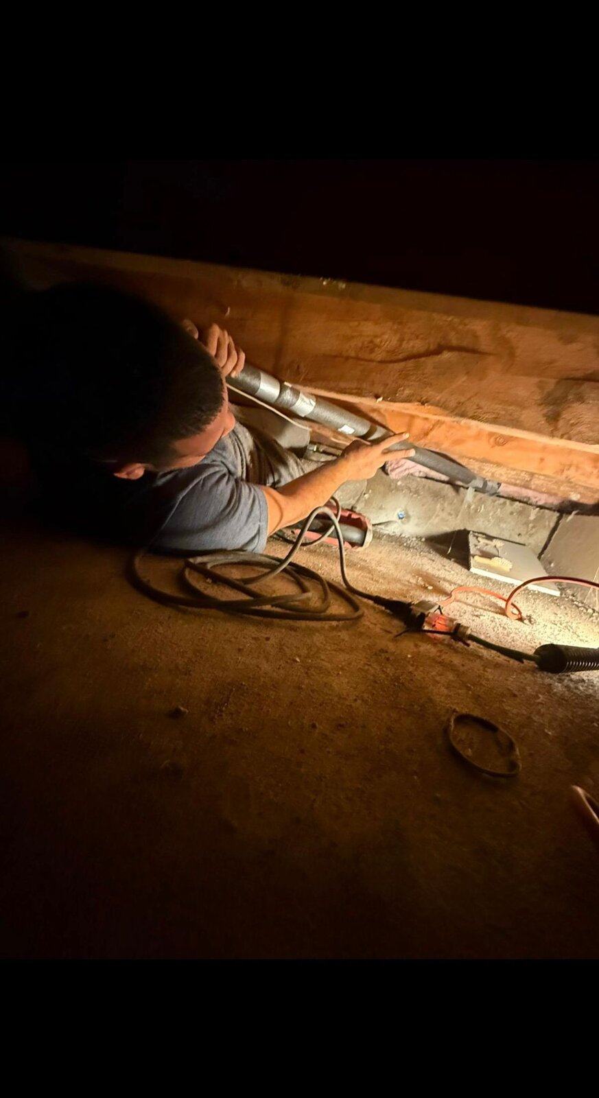 HYDROPRO plumber repairing pipes in a Vancouver crawlspace during after-hours service