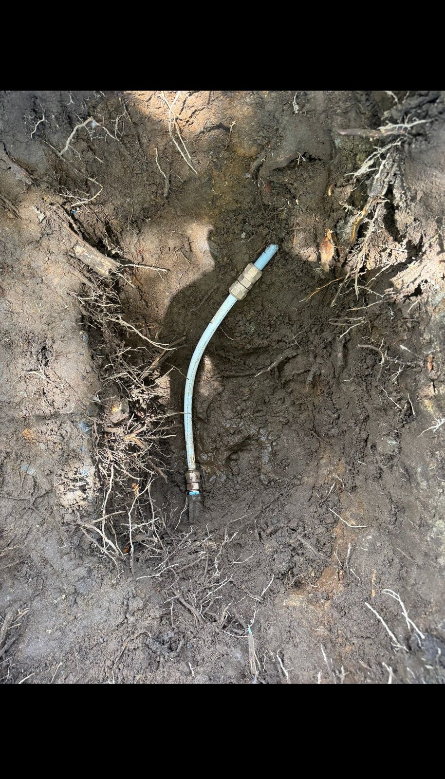 Blue polyethylene water service line exposed during water main replacement in Vancouver